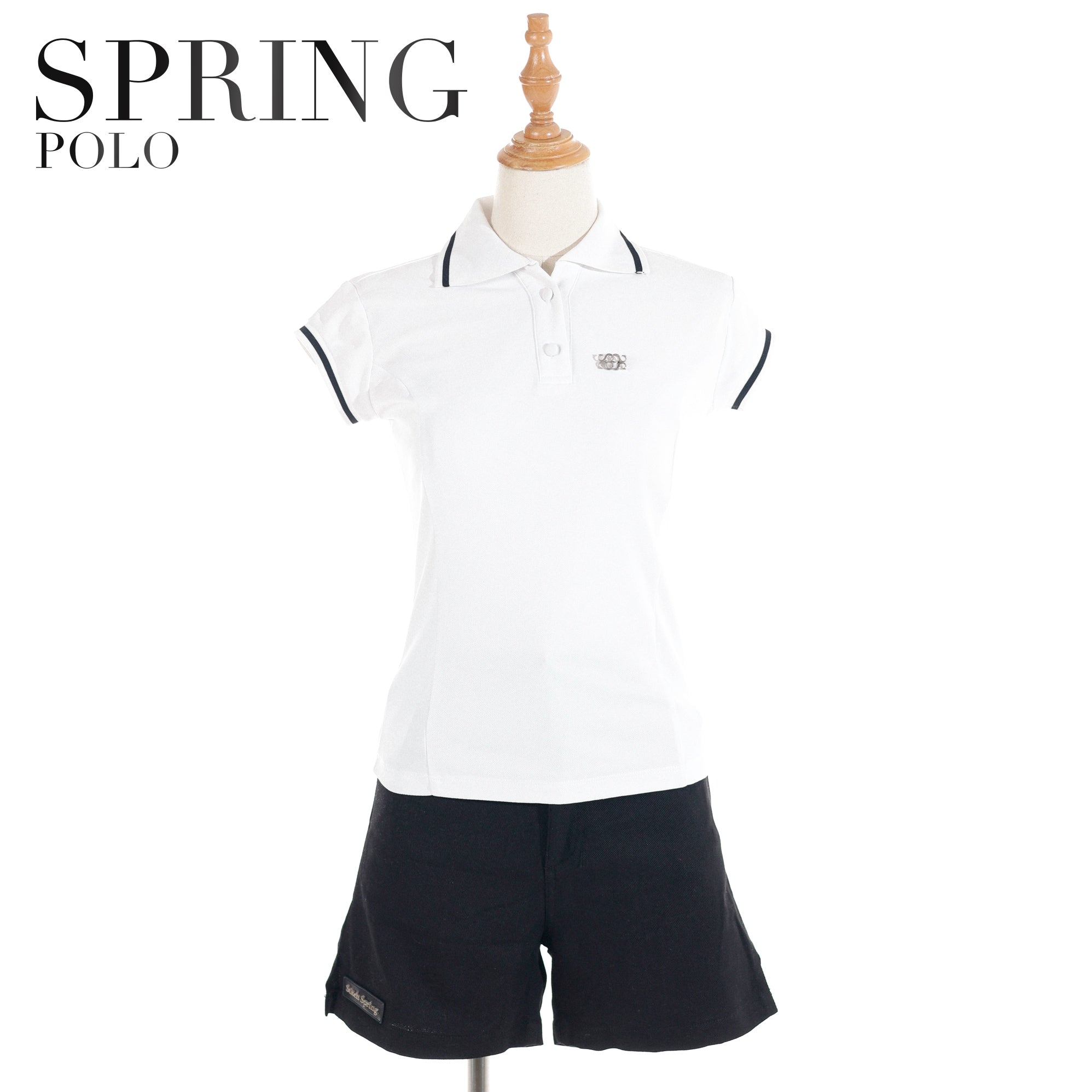 Women's white polo shirt with navy trim by Spring Polo, styled with navy shorts on a mannequin